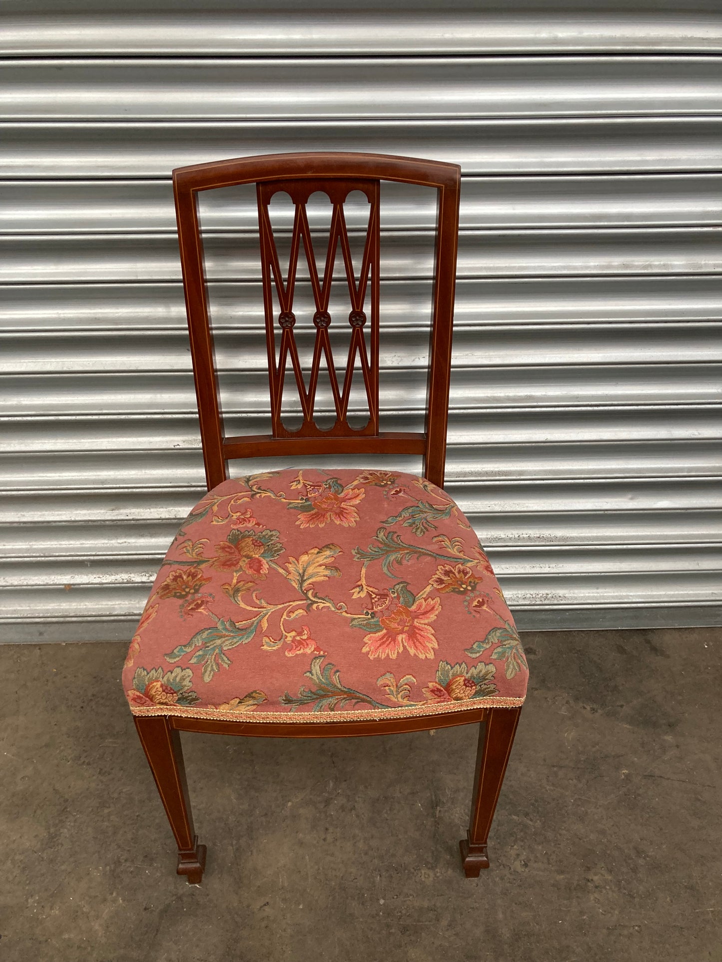 Single antique dining chair with floral seat and gold inlaid trim on back rest